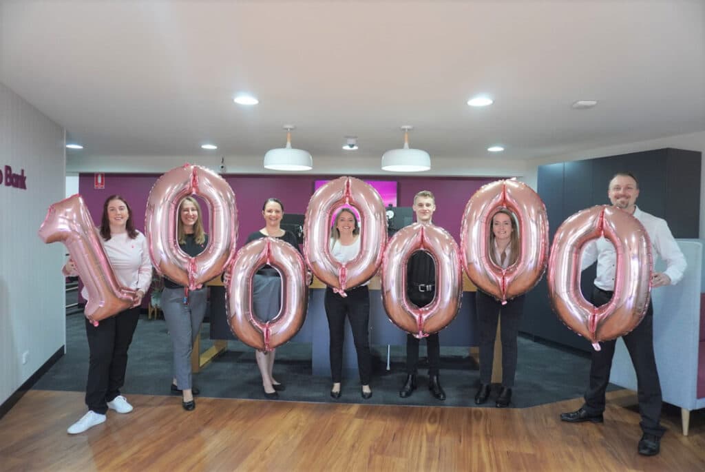 The team at Bendigo Bank Samford holding pink number balloons that show $1 000 000